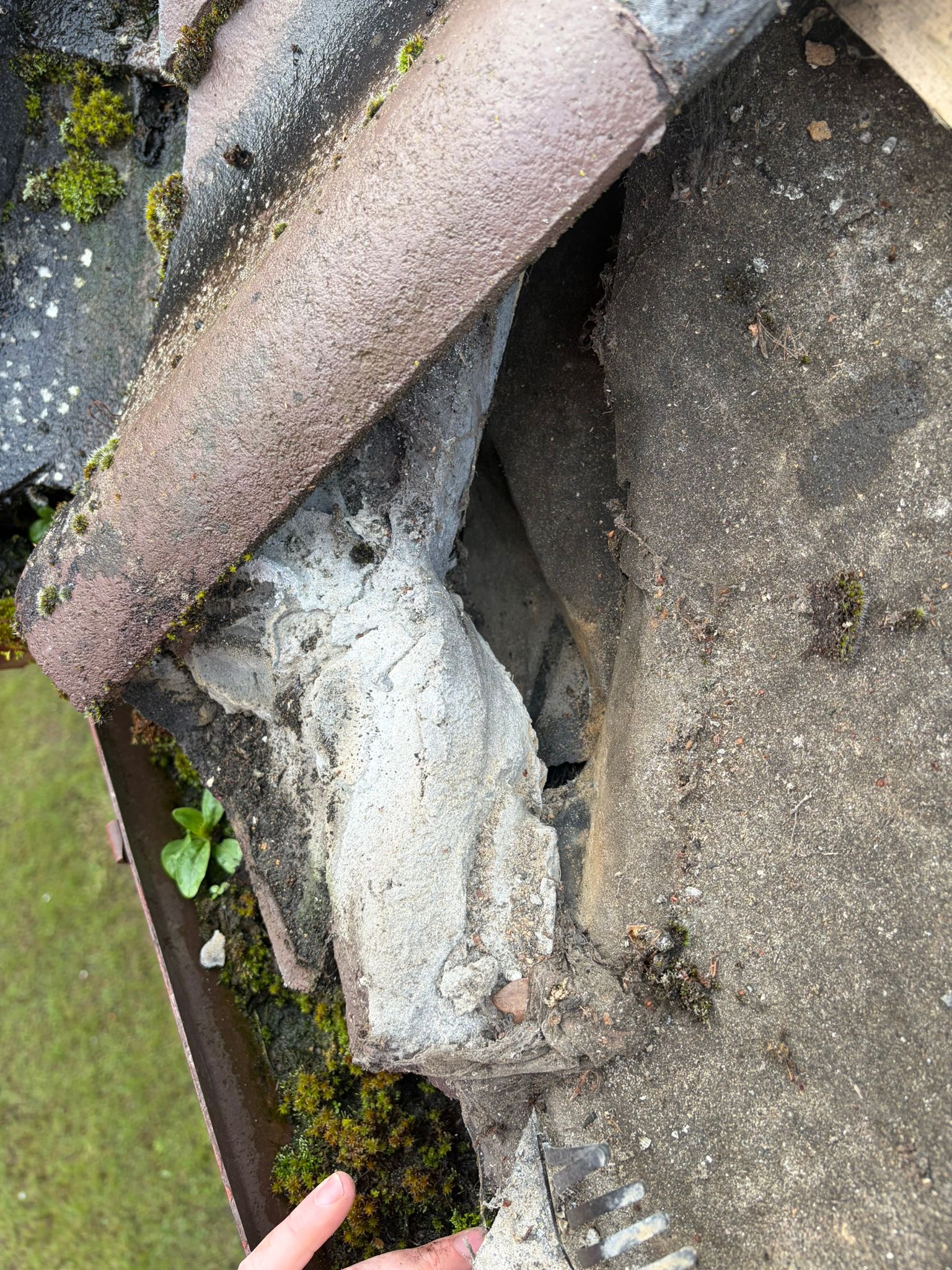 Crumbling mortar and moss around ridge tiles in Holt, Norfolk