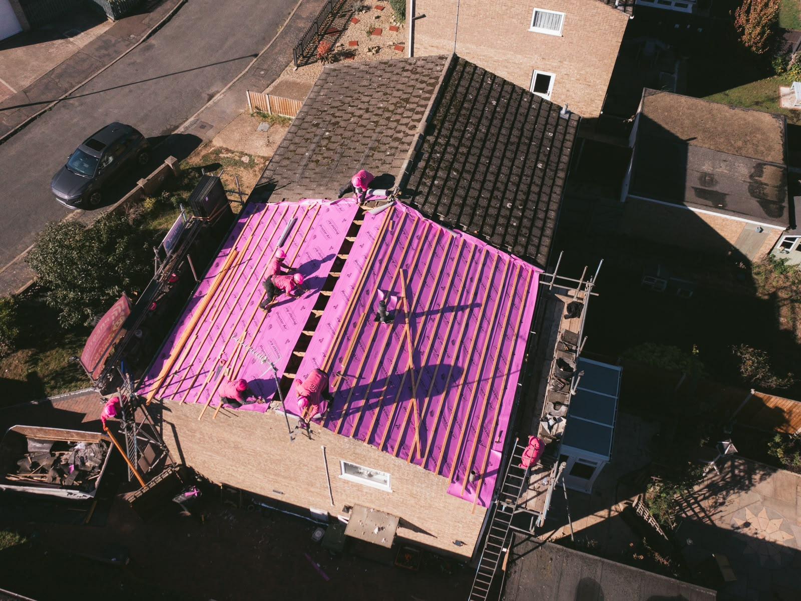 Overhead view of the roof stripped and covered in new pink breathable membrane with treated battens