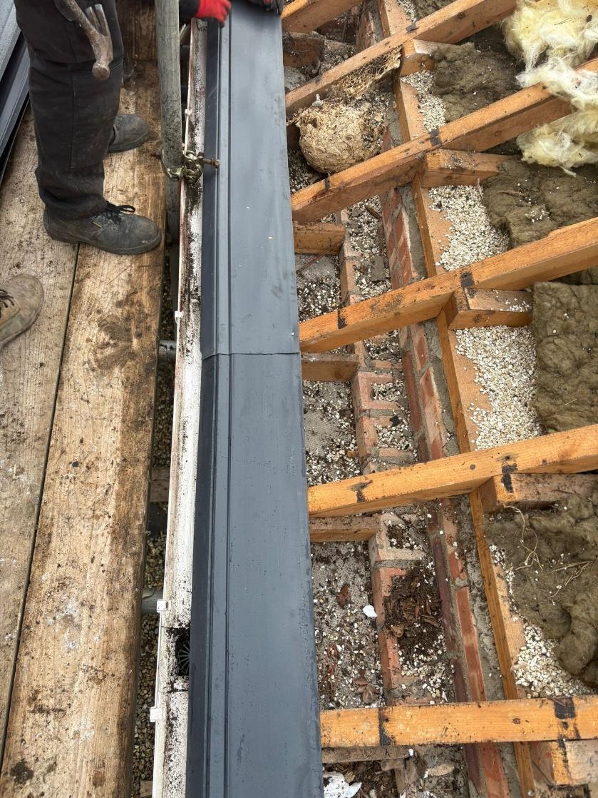 Close-up of a new eaves support tray fitted at the gutter line over the rafters