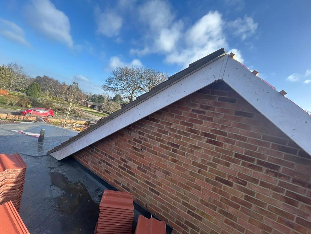 A freshly sand and cement rendered gable end finished to the new tiled roof