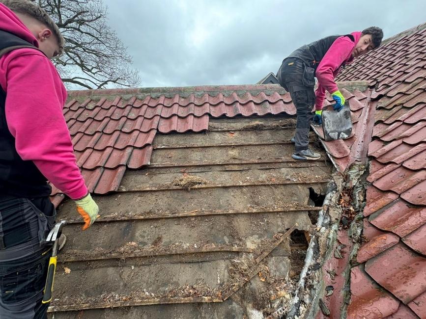 The Prestige Roof team stripping the old painted concrete tiles from the bungalow roof